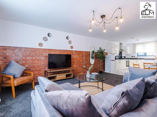 a living room with a couch and a brick wall at Elm Aparthotel , Collection of apartments Available Near Media City , Free Parking in Manchester