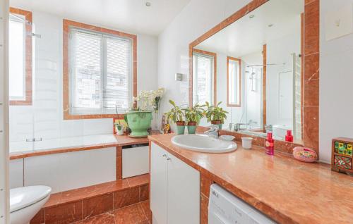 W łazience znajduje się umywalka, toaleta i lustro. w obiekcie Stunning Apartment In Neuilly-sur-seine With Kitchen w mieście Neuilly-sur-Seine
