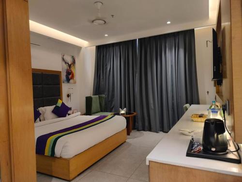 a hotel room with a bed and a desk in it at Hotel Tamarind in Sohāna