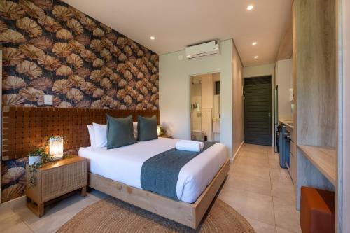 - une chambre avec un lit dans une pièce avec un mur dans l'établissement Zimbali Boulevard Suites Apartments, à Ballito