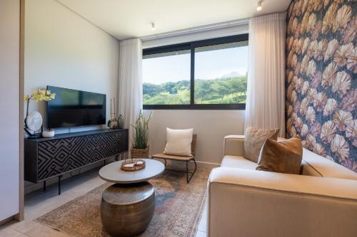 un salon avec un canapé et une télévision dans l'établissement Zimbali Boulevard Suites Apartments, à Ballito
