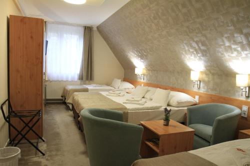 A bed or beds in a room at Zenit Panzió