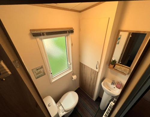 a small bathroom with a toilet and a sink at Fabulous Beach Getaway Naish Est near New Forest in New Milton
