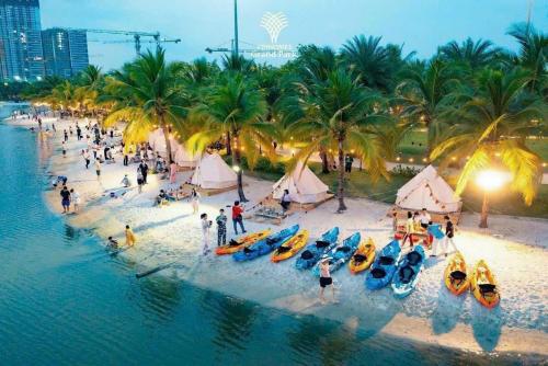 a group of people on a beach with boats in the water at Căn hộ Vinhome Grand Park - GREEN HOMESTAY in Gò Công