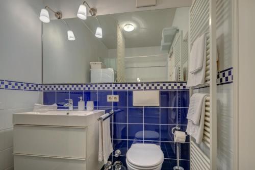 a blue and white bathroom with a toilet and a sink at VOLLMOBLIERT inkl. WiFi - 1-Zi-Wo in Munich