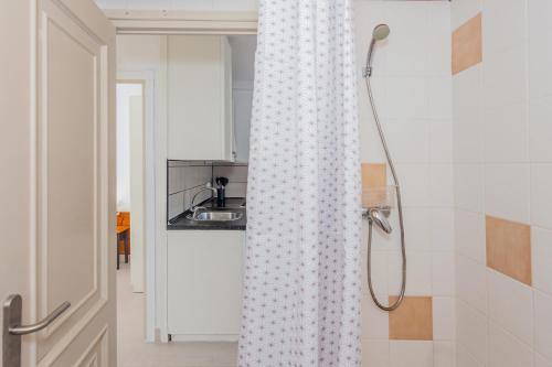 uma cortina de chuveiro na casa de banho com lavatório em Marlena em Cala'n Bosch