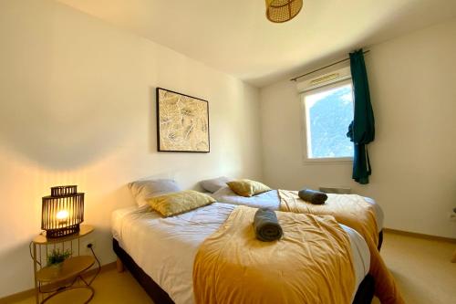 une chambre avec deux lits et une fenêtre dans l'établissement C06 Les Naïades- 2 bedrooms for 5 people !, à Avène