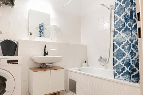 a bathroom with a sink and a washing machine at Metropolitan Charm: Stylish 2+1 Apt@ Vienna's Core in Vienna