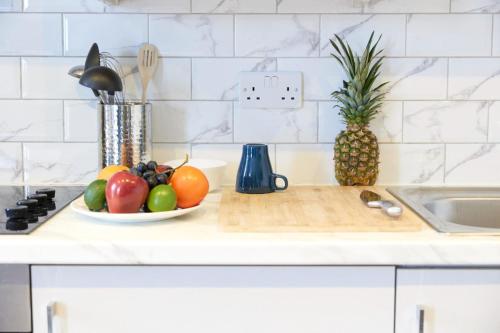 a bowl of fruit on a cutting board on a kitchen counter at Wonderful Holiday Studio in the Trendy Brick Lane in London