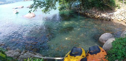 a yellow kayak in a body of water at Casa com Praia no quintal in Angra dos Reis