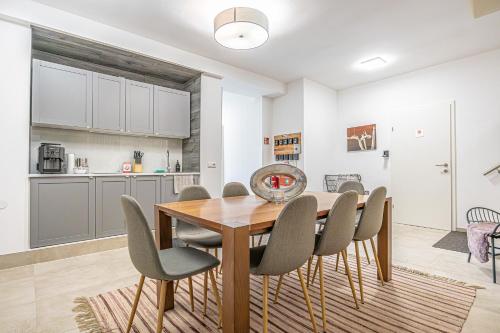 a kitchen and dining room with a wooden table and chairs at Krems Bahnhof Deluxe Rooms - near Danube River in Krems an der Donau
