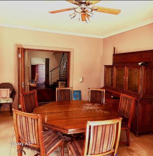 a dining room with a wooden table and chairs at 50 Arklow in Johannesburg