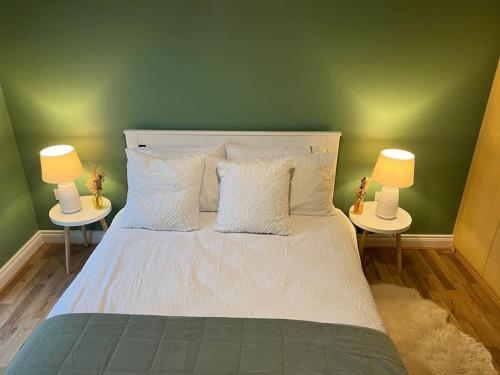 a bedroom with a white bed with two lamps at Cosy 2 Double Bed Apartment in Swords