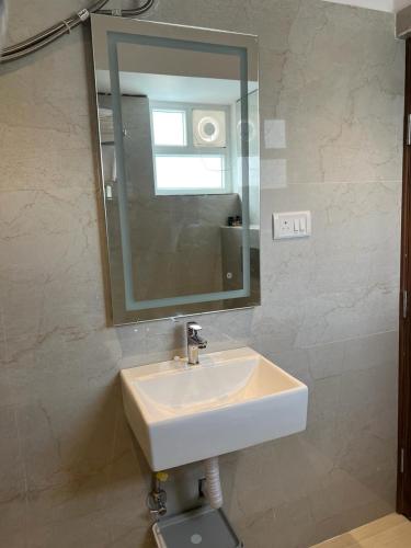a bathroom with a white sink and a mirror at Swanotel Gachibowli in Gachibowli