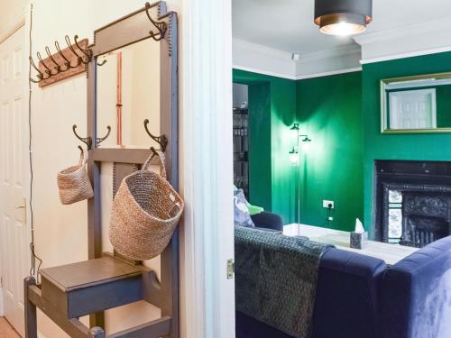 a living room with green walls and a blue couch at The Bolthole in Bolton