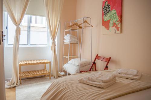 a bedroom with a bed and a window and a shelf at Impar Triplex House in Porto