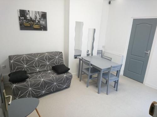 un salon avec une table et un canapé dans l'établissement Studio N°2 Boston Conciergerie Leroy, à Boulogne-sur-Mer