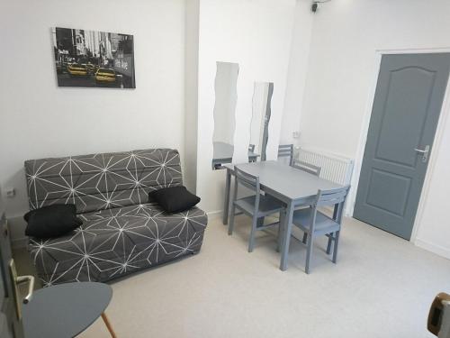 un salon avec une table et un canapé dans l'établissement Studio N°2 Boston Conciergerie Leroy, à Boulogne-sur-Mer