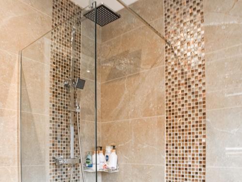 a bathroom with a shower with a glass door at Shirleys Place in Boston Spa