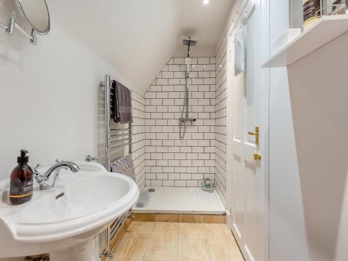 a white bathroom with a sink and a shower at The Old Stables - Uk46338 in Canisbay