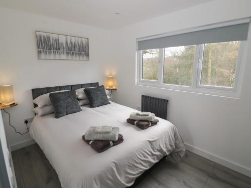 a bedroom with a white bed with two towels on it at Goldthorne Lodge in Kidderminster