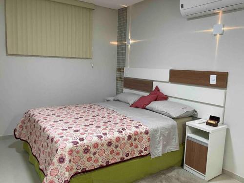 Habitación pequeña con cama y mesa pequeña en 7 - Apartamento tranquilo e charmoso en Manaus