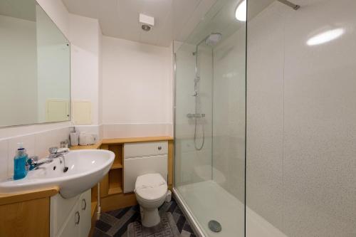 a bathroom with a shower and a toilet and a sink at Pure Apartments 2 Bed Duloch - Dunfermline in Fife