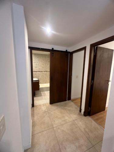 einen leeren Flur mit Tür und Bad in der Unterkunft nardos suites in Balcarce
