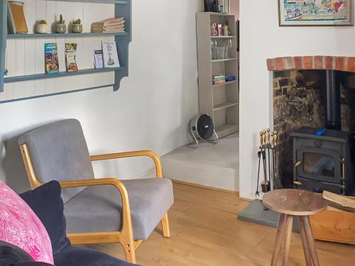 a living room with a chair and a fireplace at Smithy End in Chard