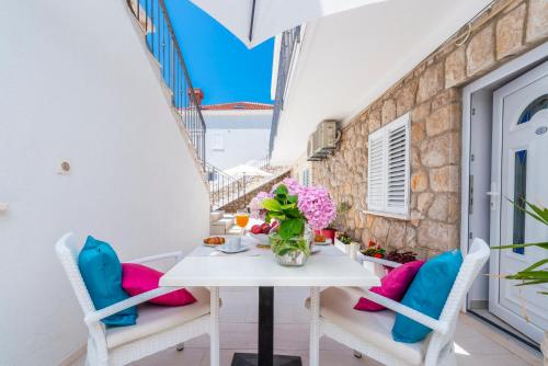 a table with chairs and flowers on a balcony at Villa Boro 3 in Dubrovnik