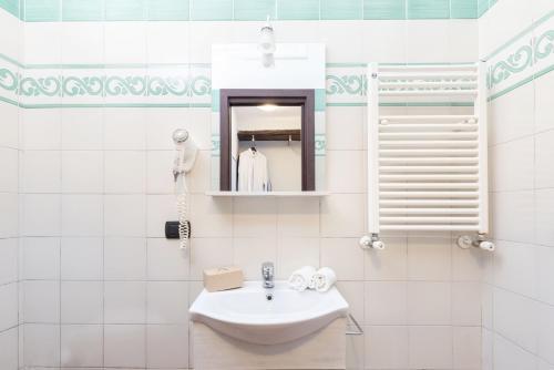a white bathroom with a sink and a mirror at Casale Antonietta in Sorrento