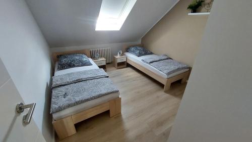 two beds in a small room with a skylight at Schöne Ferienwohnung in Münster