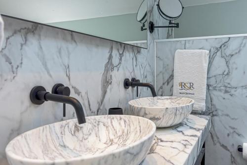 two sinks in a bathroom with marble walls at Goferydd, South Stack, Anglesey, 4 bed luxury home, hot tub, dog friendly in Holyhead