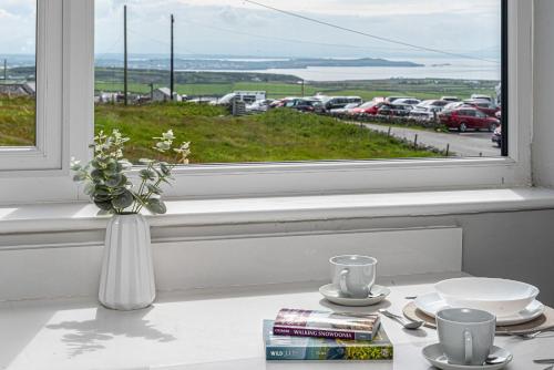 a vase of flowers sitting on a table in a window at Goferydd, South Stack, Anglesey, 4 bed luxury home, hot tub, dog friendly in Holyhead
