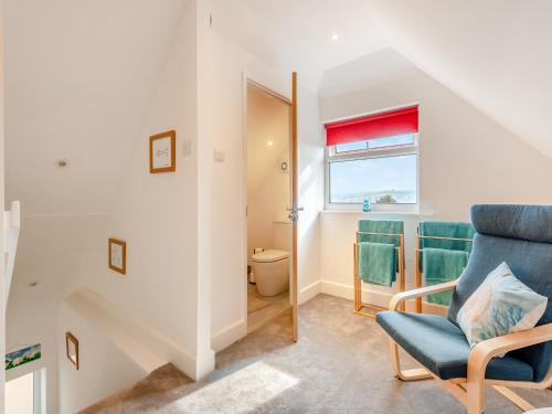 a living room with a blue chair and a window at The Laurels in Goodwick