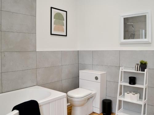 a bathroom with a white toilet and a bath tub at Main Street Flat C-uk46563 in Prestwick