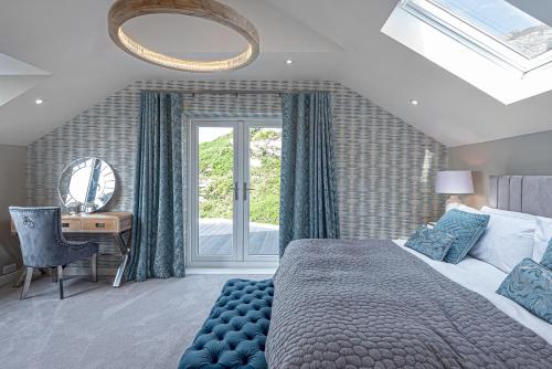 Schlafzimmer mit einem Bett und einem Schreibtisch mit einem Spiegel in der Unterkunft Goferydd, South Stack, Anglesey, 4 bed luxury home, hot tub, dog friendly in Holyhead
