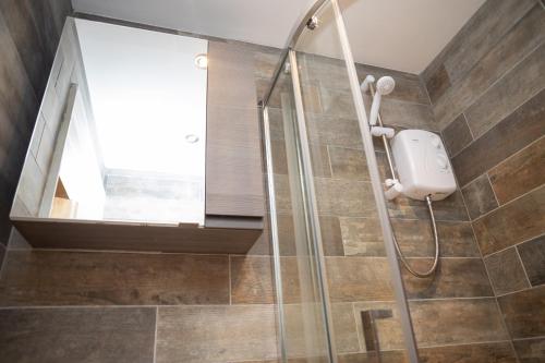 a shower in a bathroom with a glass shower stall at No. 1 Cliffside New Quay in New Quay