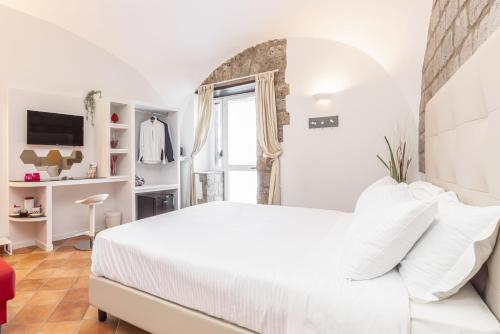 a white bedroom with a white bed and a window at Casale Antonietta in Sorrento