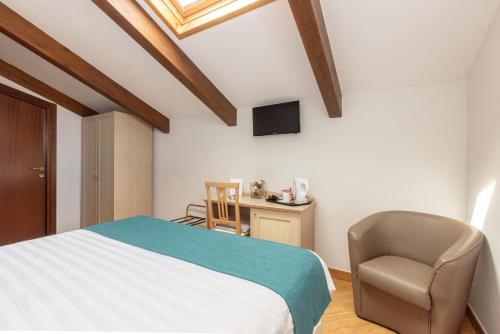a bedroom with a bed and a chair and a desk at Casale Antonietta in Sorrento
