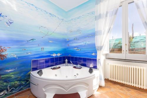 a bathroom with a bath tub with a fish mural at Casale Antonietta in Sorrento