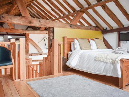 um quarto com uma cama grande e uma cadeira em Uk46591 - Polecat Barn em Wivelsfield Green