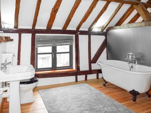 a bathroom with a tub and a sink and a toilet at Uk46591 - Polecat Barn in Wivelsfield Green