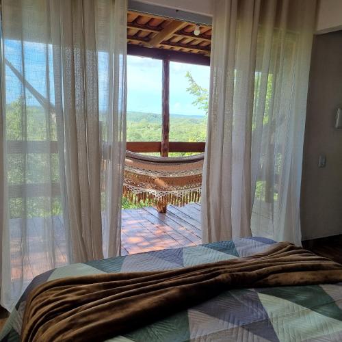 a bedroom with a bed and a large window at Pousada Bambuí Terra Ronca in São João