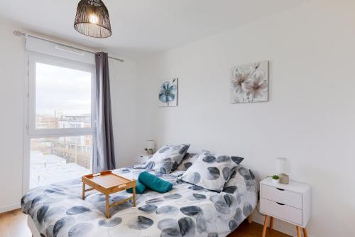 a bedroom with a bed with a table and a window at Confort Moderne Argenteuil – Proche Paris in Argenteuil