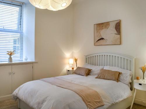 a bedroom with a large white bed with two pillows at Doodles Holiday Home in Eyemouth
