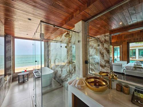 a bathroom with a shower and a tub and a sink at Hotel Villa AoKhanom Beachfront in Khanom