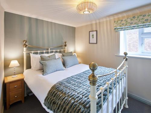 um quarto com uma cama branca e uma janela em Cobblers Cottage em Barnard Castle