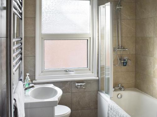 a bathroom with a sink and a toilet and a window at Avondale in Clacton-on-Sea