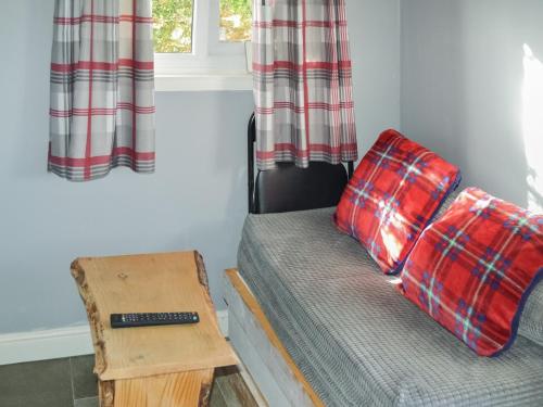 a room with a bed and a table and a couch at The Shepherds Hut - Uk46633 in Culbokie